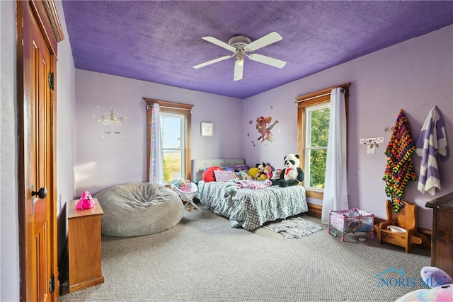 bedroom with carpet, ceiling fan, and a textured ceiling