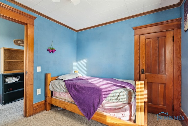 carpeted bedroom with ornamental molding and ceiling fan