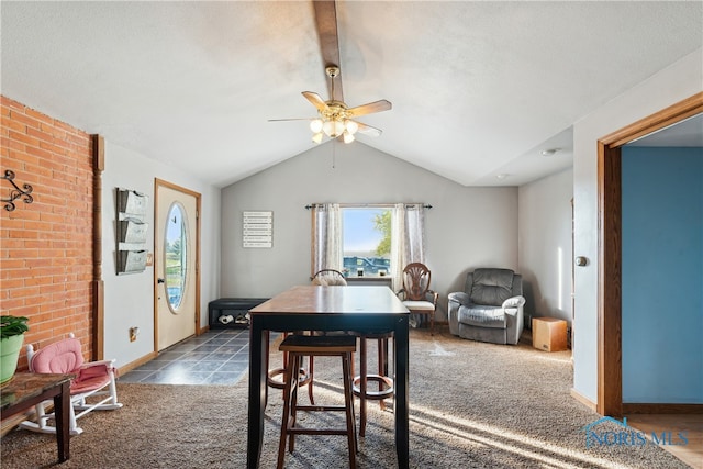 carpeted dining room featuring ceiling fan and vaulted ceiling