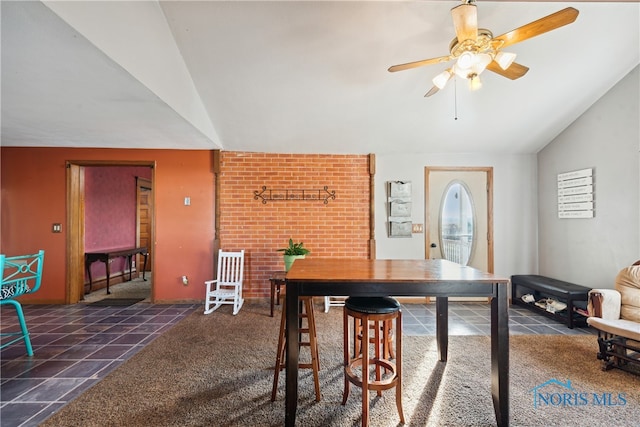 dining room with ceiling fan, lofted ceiling, and dark colored carpet