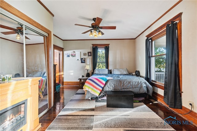 bedroom with crown molding, dark wood-type flooring, and ceiling fan