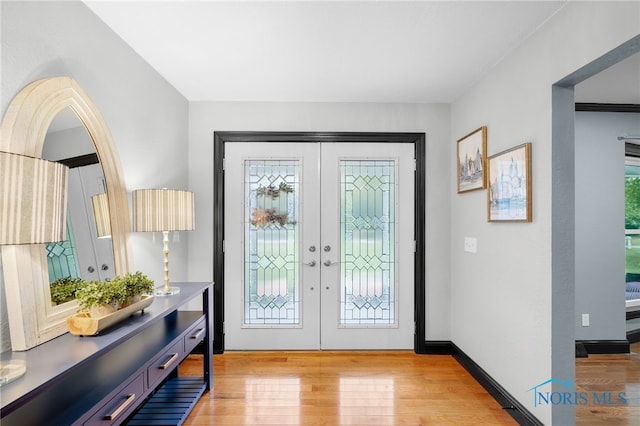 foyer with light wood-type flooring and french doors