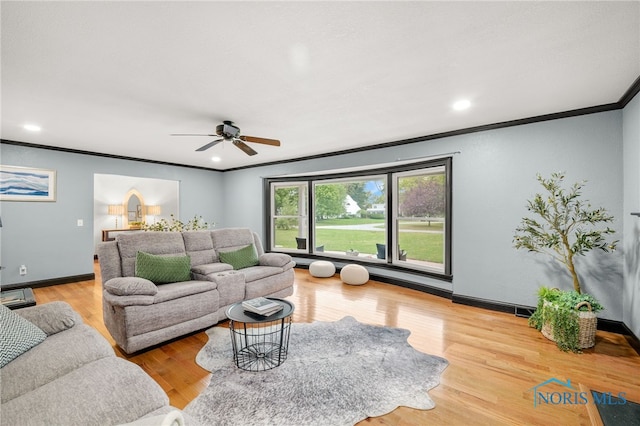 living room featuring crown molding, ceiling fan, and light hardwood / wood-style flooring