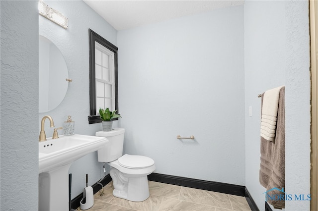 bathroom featuring sink, toilet, and tile patterned floors