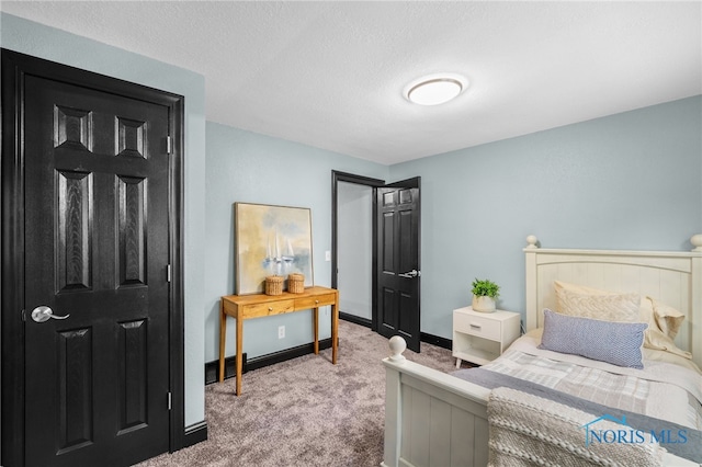 bedroom with a textured ceiling and carpet floors