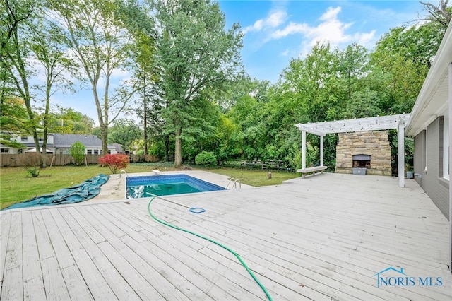 view of swimming pool with a lawn, a wooden deck, and a pergola