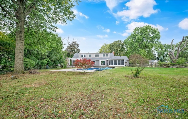 back of house featuring a lawn and a patio area