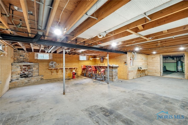 basement featuring water heater and a fireplace