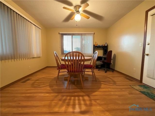 dining space with a textured ceiling, light hardwood / wood-style floors, and ceiling fan