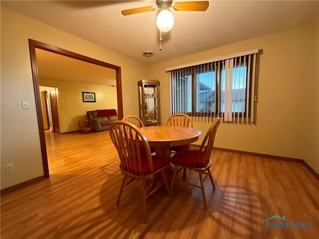 dining room with ceiling fan and hardwood / wood-style flooring