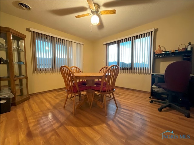 dining area featuring ceiling fan, a textured ceiling, and wood-type flooring