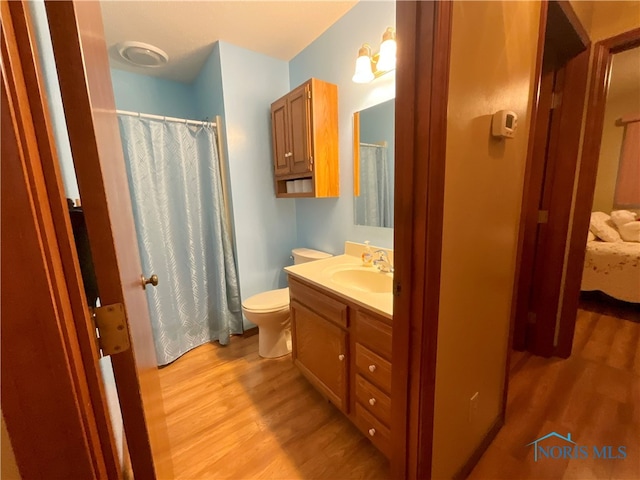 bathroom with vanity, hardwood / wood-style floors, and toilet