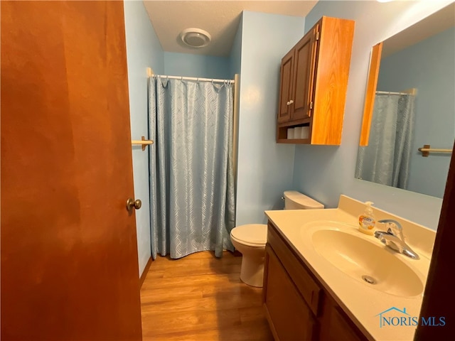 bathroom featuring vanity, hardwood / wood-style floors, and toilet