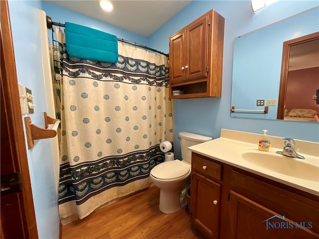 bathroom with wood-type flooring, vanity, toilet, and a shower with curtain