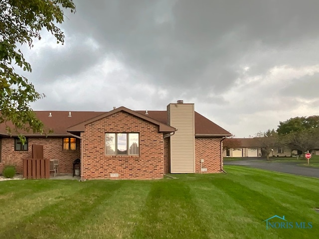 rear view of property featuring a lawn