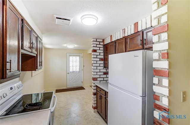 kitchen featuring a textured ceiling and white appliances