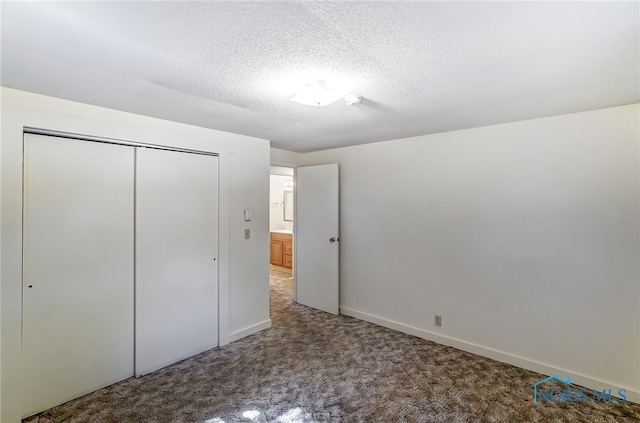 unfurnished bedroom featuring a textured ceiling, a closet, and carpet flooring