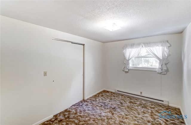 spare room with carpet floors, a textured ceiling, and baseboard heating