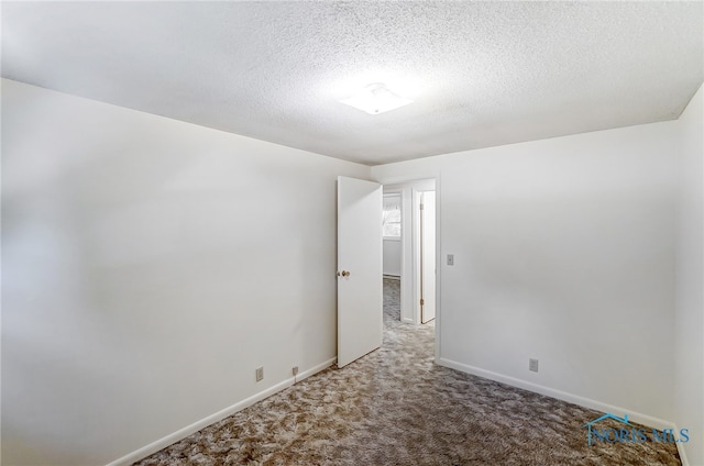 empty room with a textured ceiling and carpet