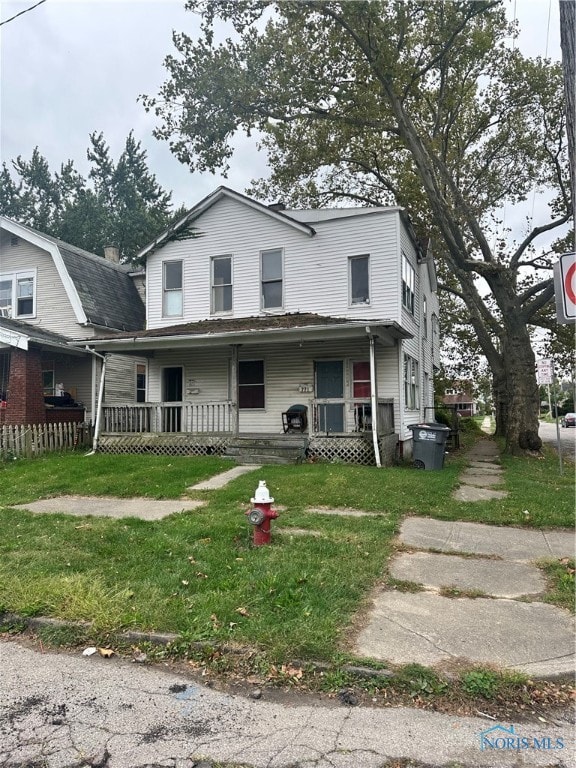 view of front of home with a porch and a front lawn