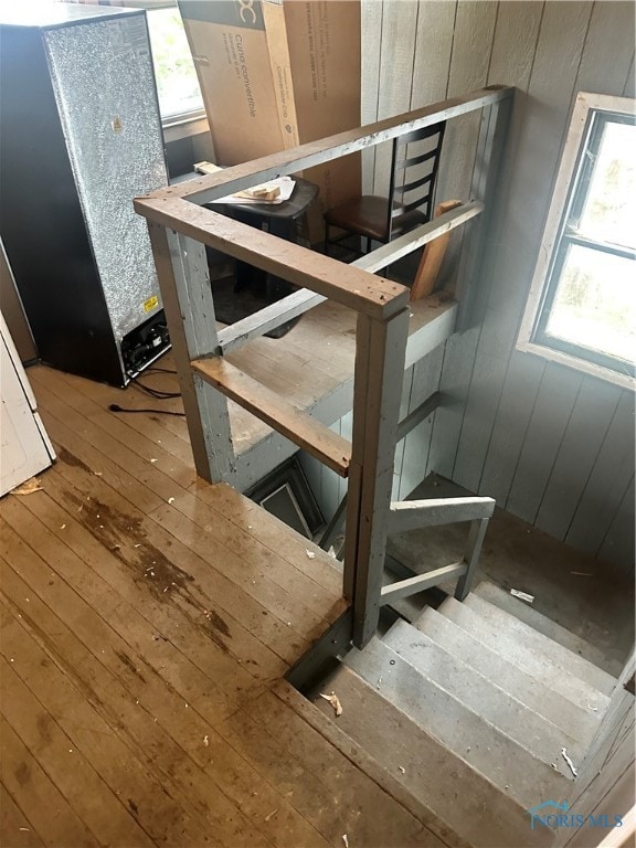 staircase featuring hardwood / wood-style flooring and wood walls