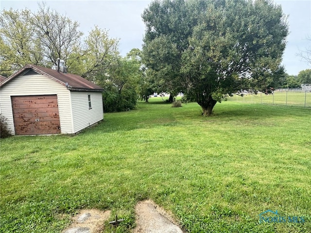 view of yard featuring a garage and an outbuilding