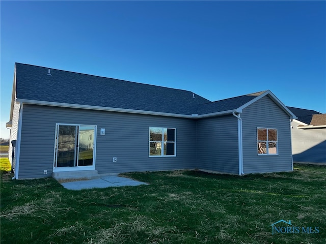 rear view of property with a lawn