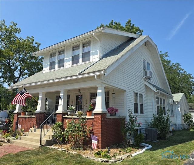 view of front facade featuring a front yard, cooling unit, and a porch