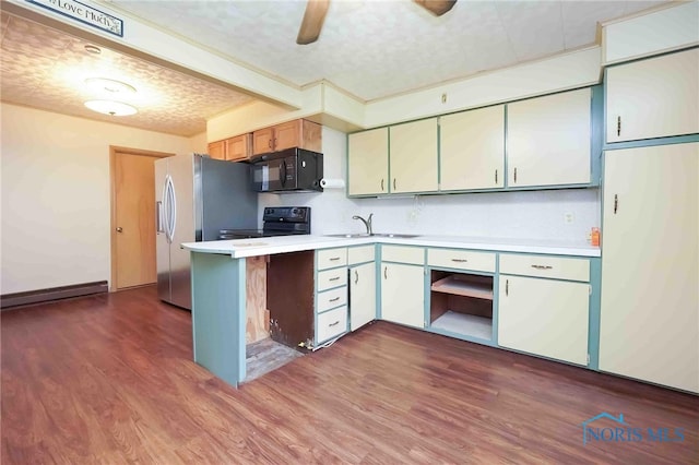 kitchen with white cabinets, a textured ceiling, black appliances, wood-type flooring, and sink