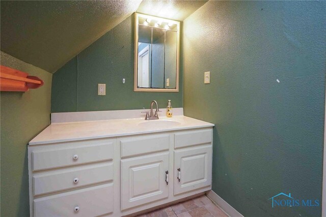 bathroom with lofted ceiling and vanity