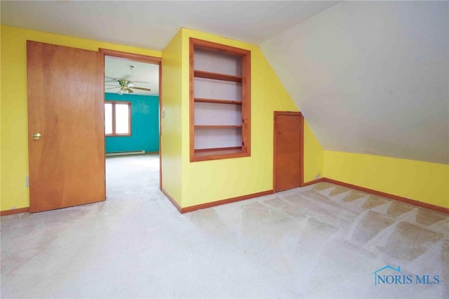 additional living space featuring vaulted ceiling, ceiling fan, light carpet, and a baseboard radiator