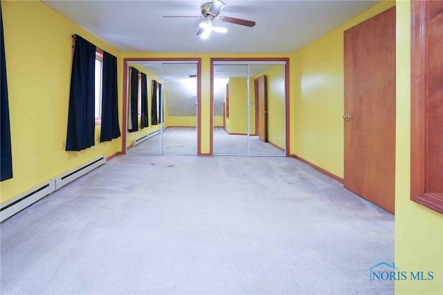 empty room featuring light colored carpet, ceiling fan, and baseboard heating