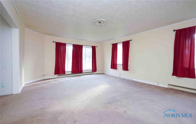 spare room with carpet floors, ornamental molding, and a baseboard heating unit