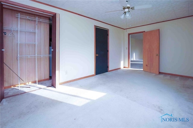 carpeted empty room with ceiling fan and crown molding