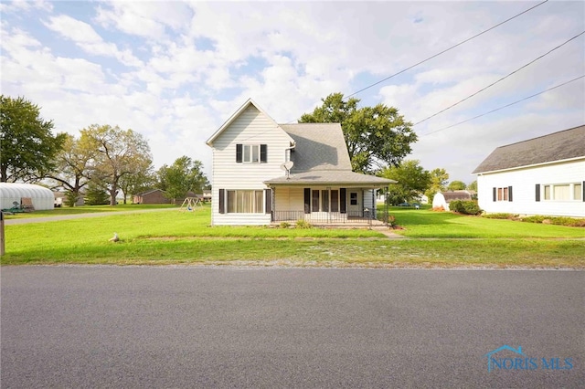 farmhouse featuring a porch and a front lawn