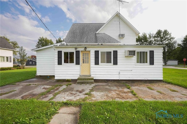 view of front of property featuring a patio, a front lawn, and a wall mounted AC