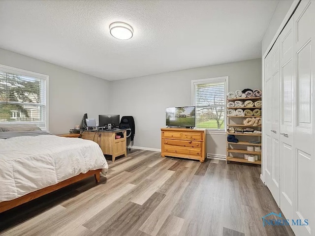 bedroom with a textured ceiling, hardwood / wood-style flooring, and a closet