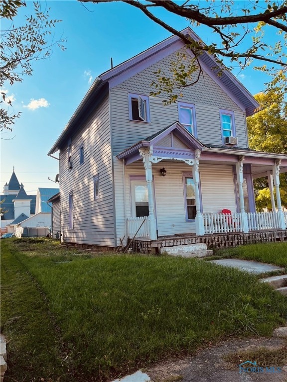 view of front of property featuring cooling unit, a front lawn, and a porch