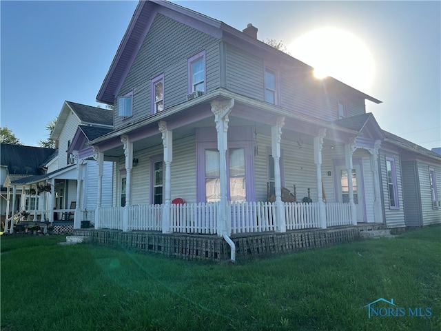 view of home's exterior with covered porch and a yard