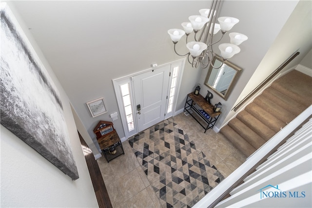 tiled entryway with a chandelier