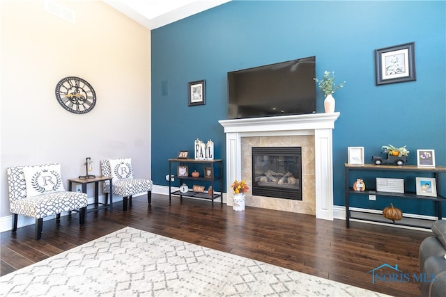 living area featuring dark hardwood / wood-style flooring and a tile fireplace