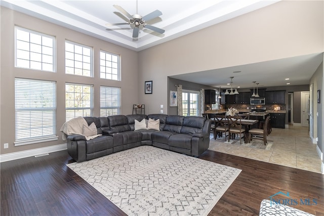 living room with ceiling fan, dark hardwood / wood-style flooring, and a wealth of natural light