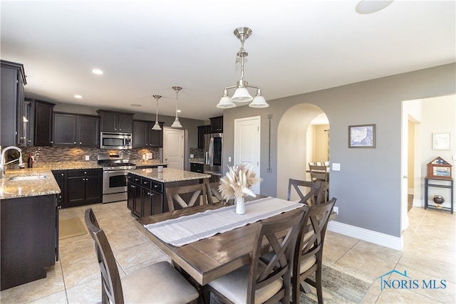 dining space featuring sink and light tile patterned floors