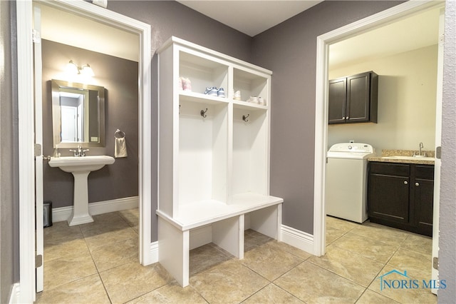 mudroom featuring light tile patterned floors, sink, and washer / clothes dryer