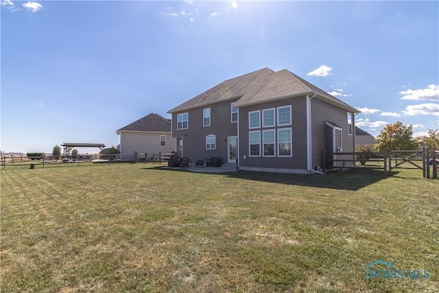 back of property with a lawn and a patio area