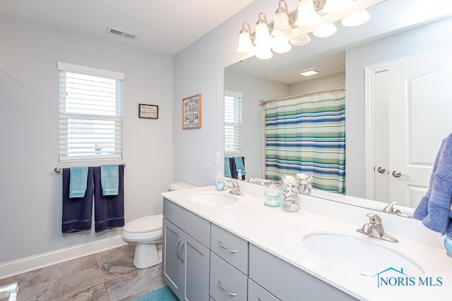 bathroom with curtained shower, vanity, and toilet