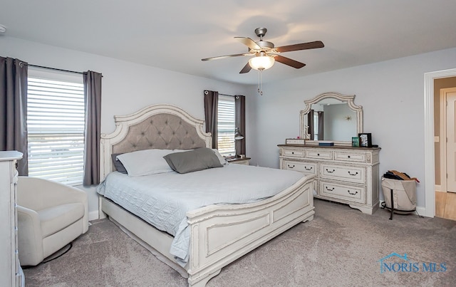 carpeted bedroom featuring multiple windows and ceiling fan