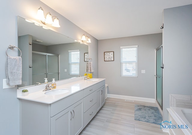 bathroom featuring a wealth of natural light, wood-type flooring, vanity, and separate shower and tub