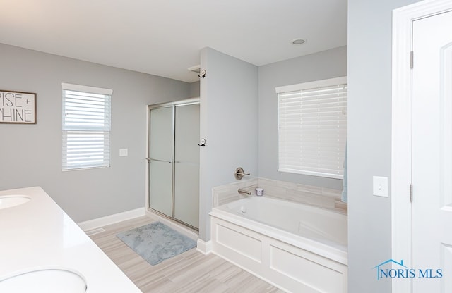 bathroom with independent shower and bath, vanity, and hardwood / wood-style flooring