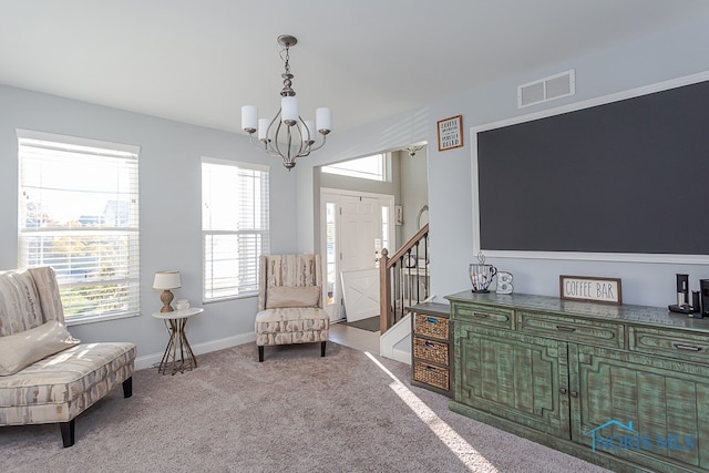 living area featuring light colored carpet and a notable chandelier